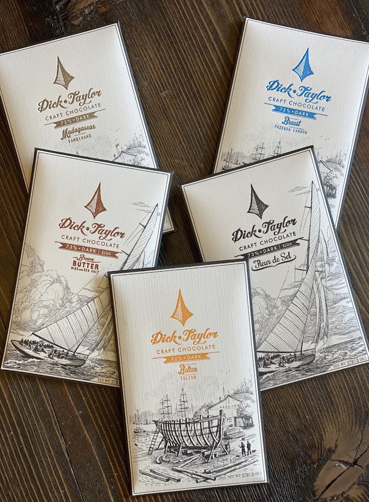 Five craft chocolate bars arranged on dark wood